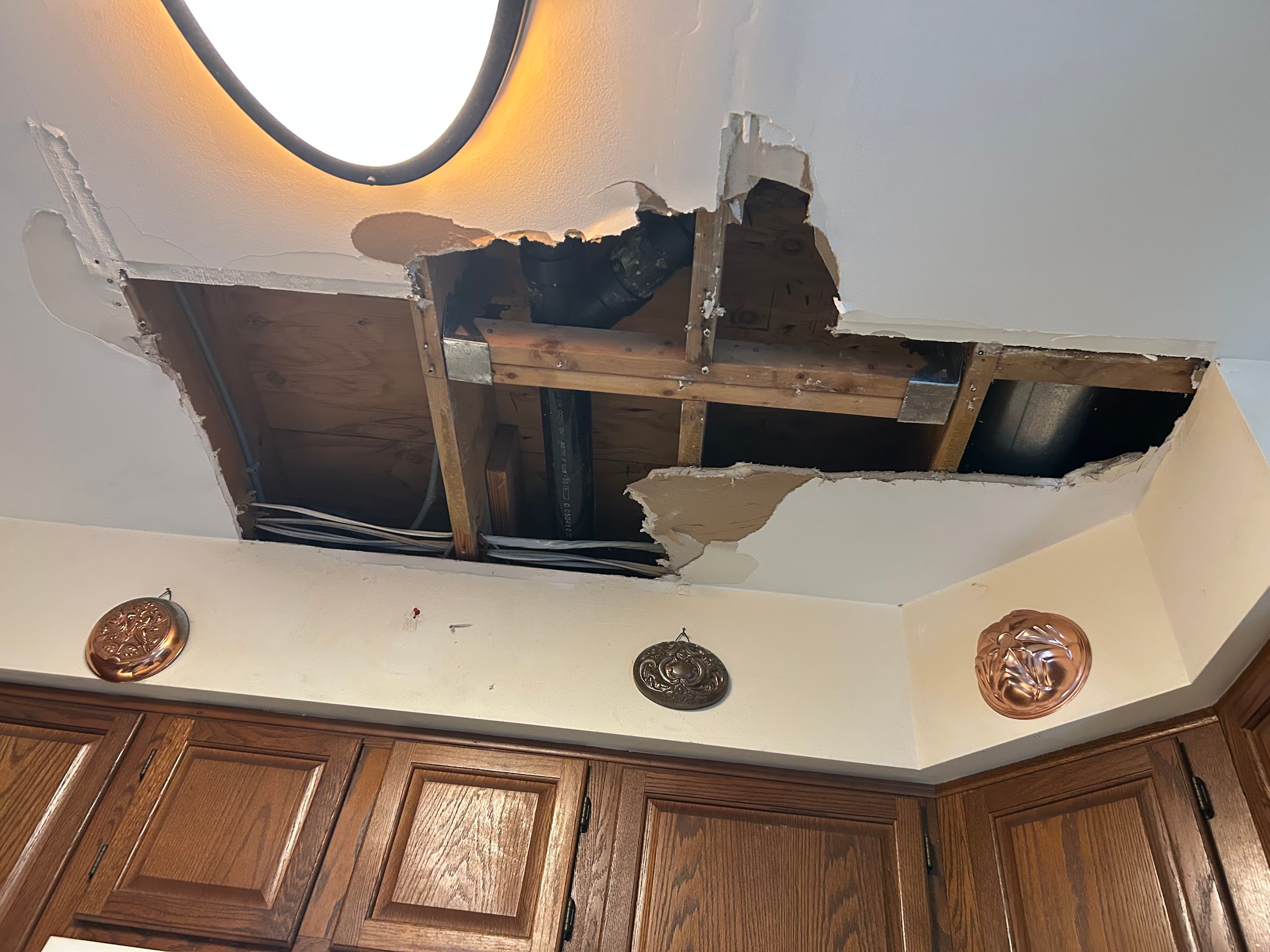 Interior ceiling damage from a roof leak, exposed joists and water-damaged drywall