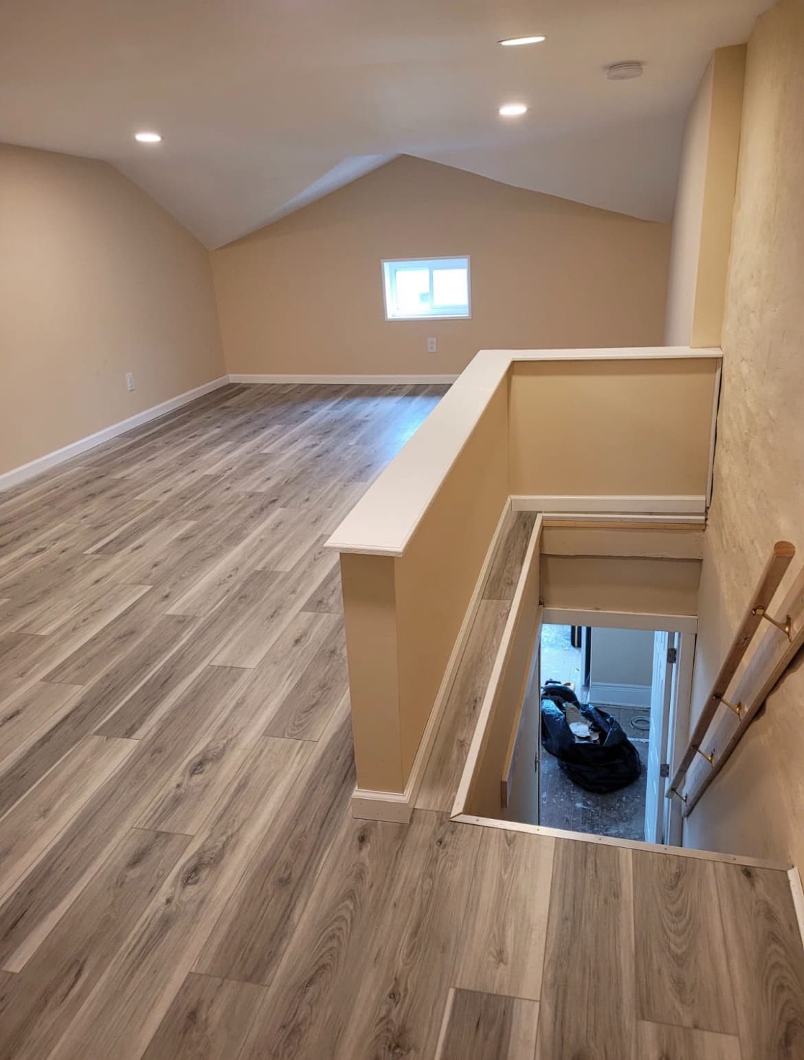 Finished attic space with gray luxury vinyl plank flooring and vaulted ceiling