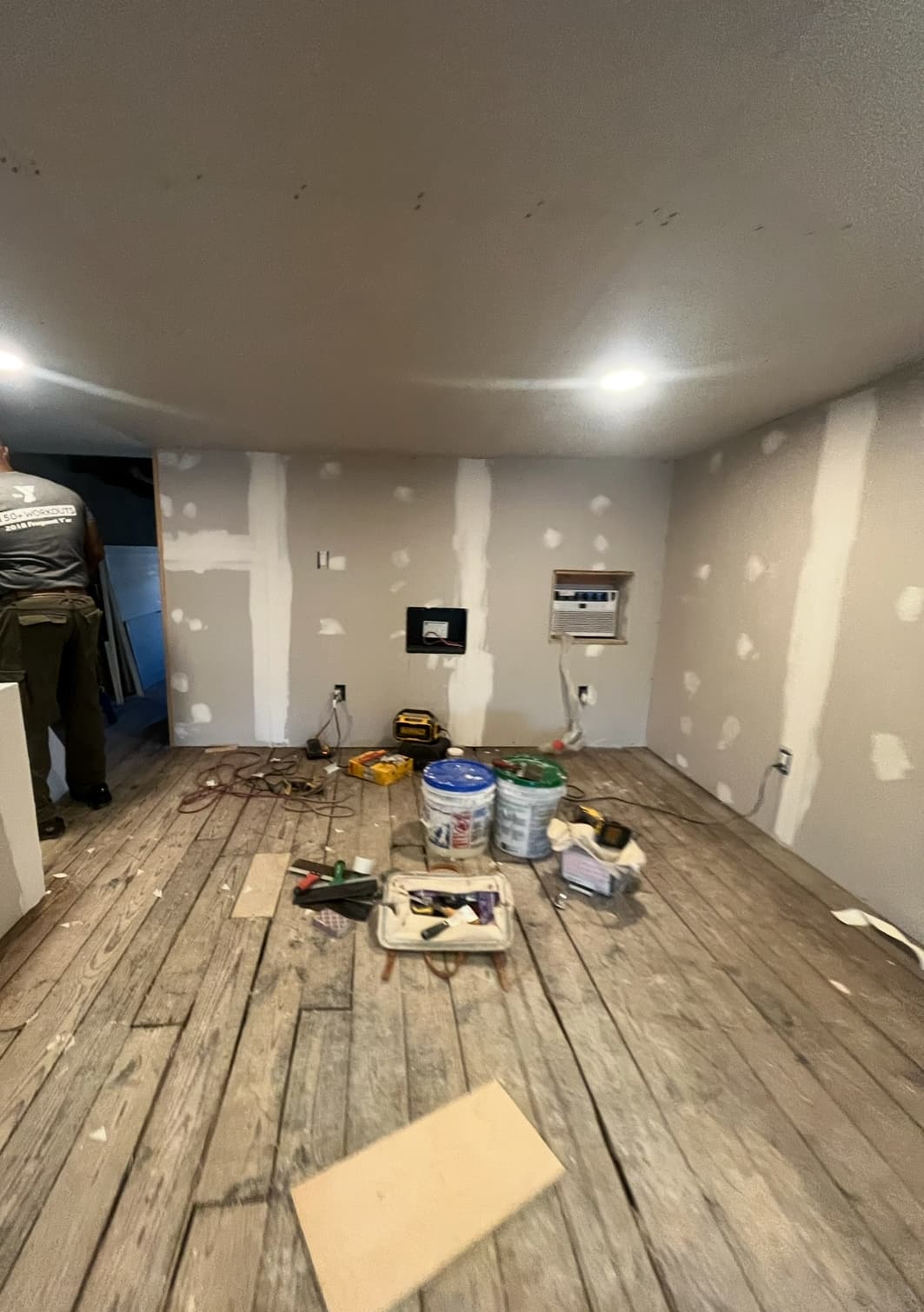 Interior room mid-renovation with drywall installed and electrical outlets roughed in